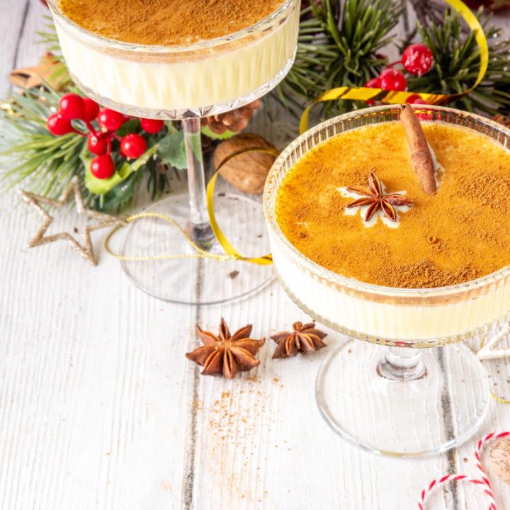 Holiday eggnog martini with cinnamon, star anise, and Christmas decorations