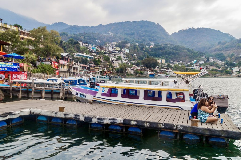 Lanchas docked at the Santiago Atitlán waterfront with the village hillside behind — the arrival point for Holy Week visitors coming by boat across Lake Atitlán