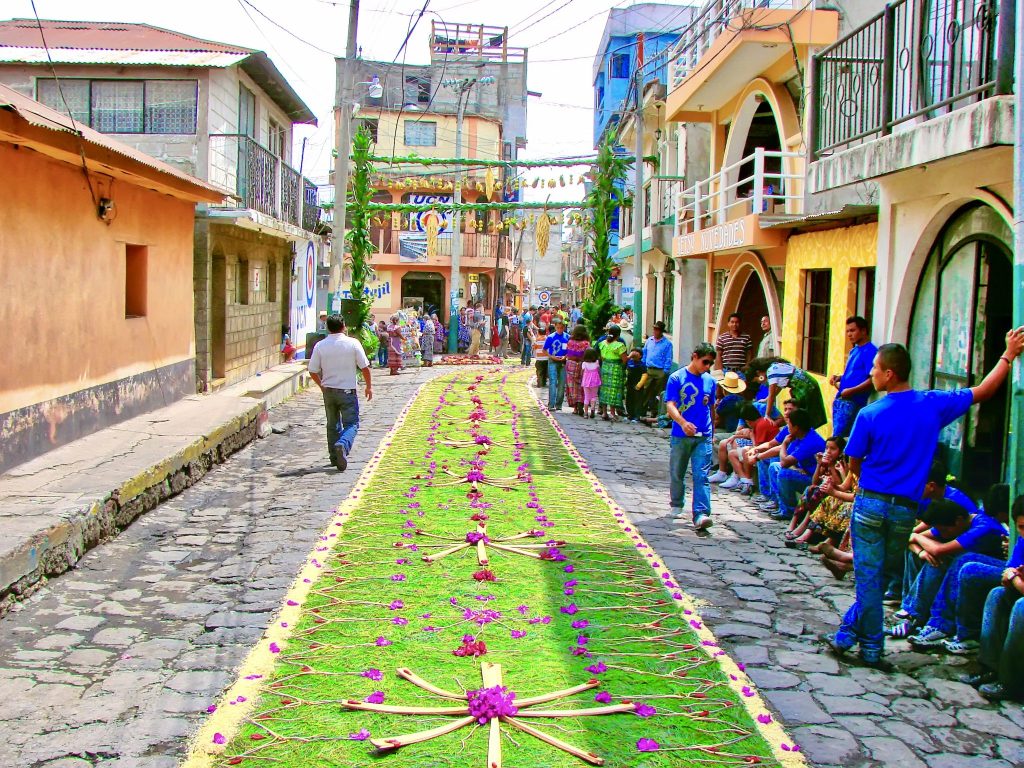 A flower alfombra stretches down a cobblestone street in Panajachel as the Holy Week procession approaches — read our complete guide to Semana Santa at Lake Atitlán Guatemala including Panajachel, Santiago Atitlán, San Pedro and more