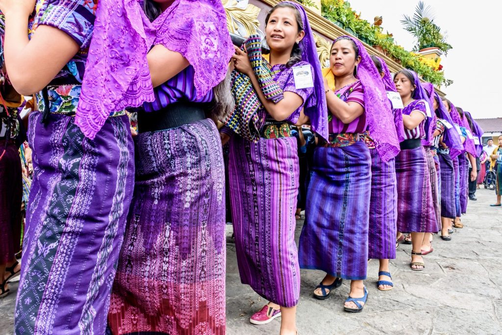Tz'utujil women in traditional purple huipiles and cortes with purple lace mantillas carrying the Virgin's anda during the Good Friday procession — Holy Week in Santiago Atitlán, Guatemala