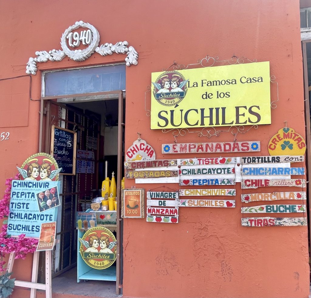 Fachada de La Famosa Casa de los Suchiles en la Zona 1 de la Ciudad de Guatemala, fundada en 1940, con letreros de bebidas tradicionales guatemaltecas