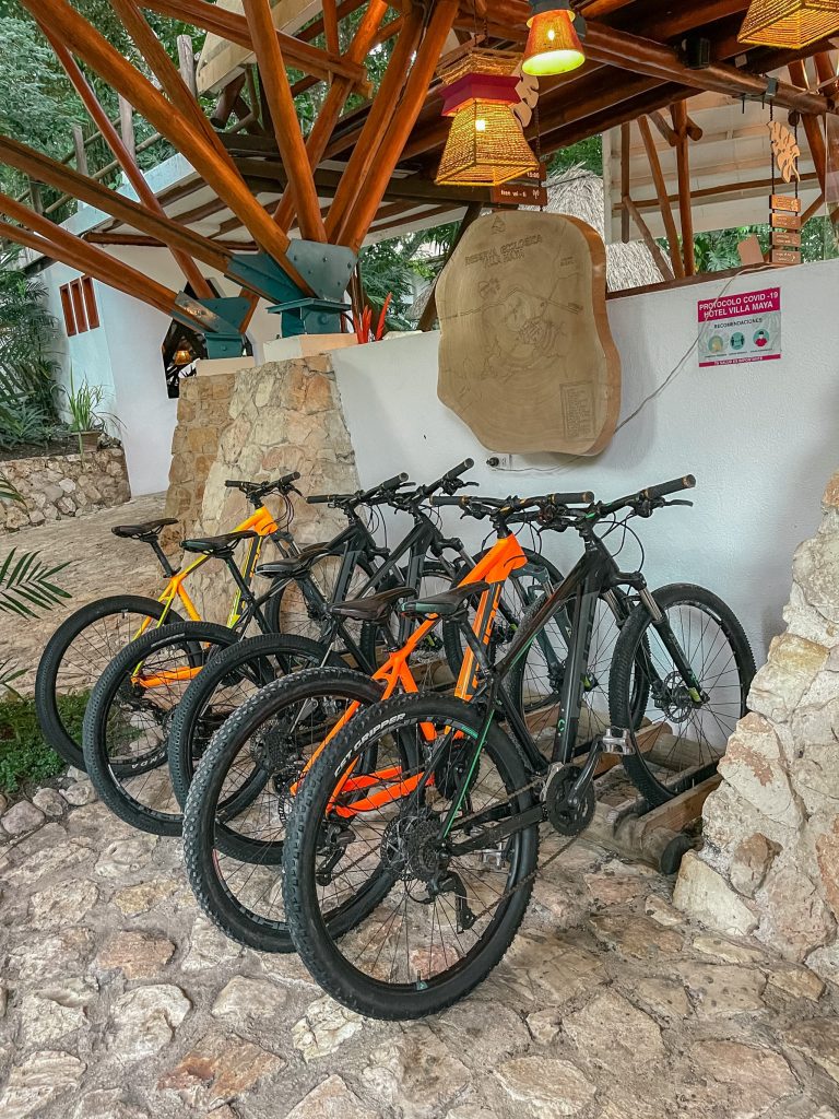 Mountain bikes available for rental at the lobby of Villa Maya hotel in Petén Guatemala, with a carved woo