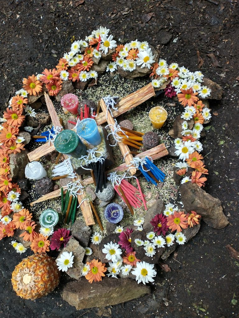 Circular Mayan fire altar with colorful candles, flowers, and ceremonial offerings in Guatemala