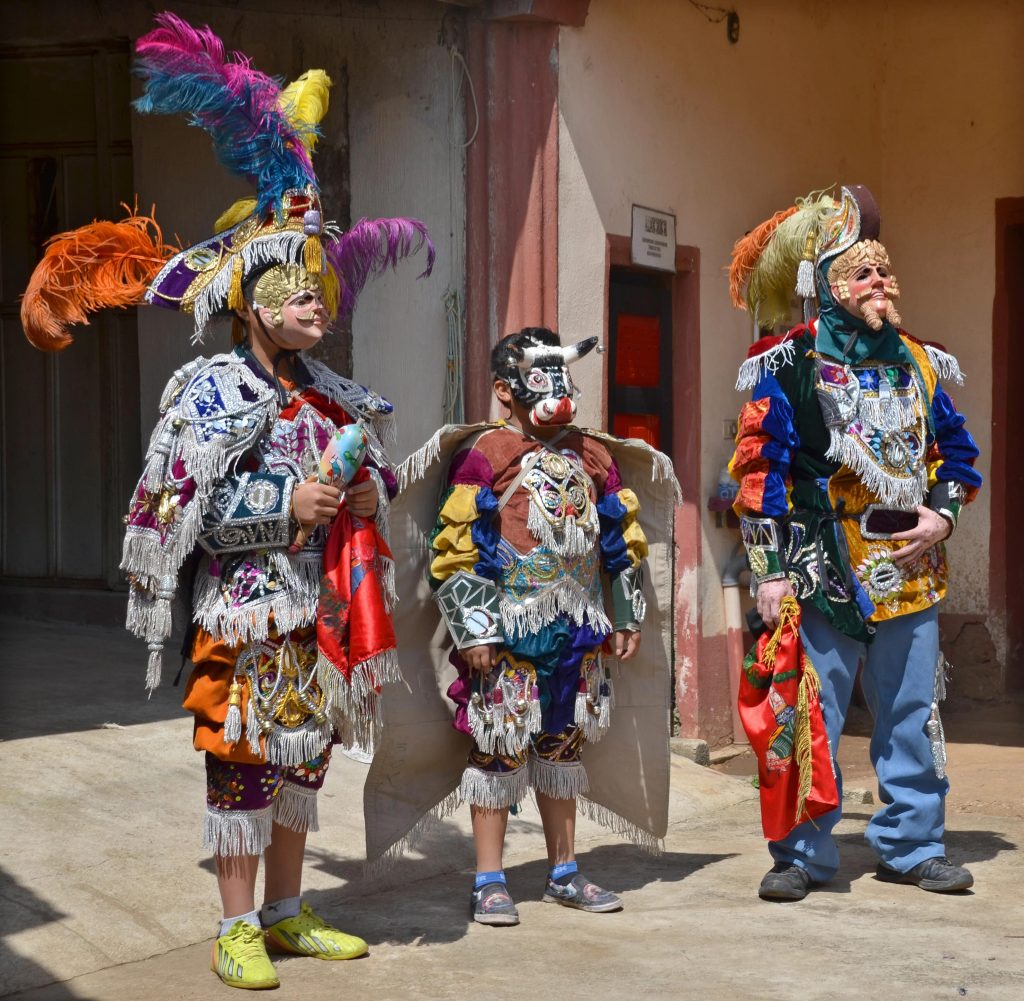 Traditional masked dancers wearing colorful ceremonial costumes in Santiago Atitlán, Guatemala