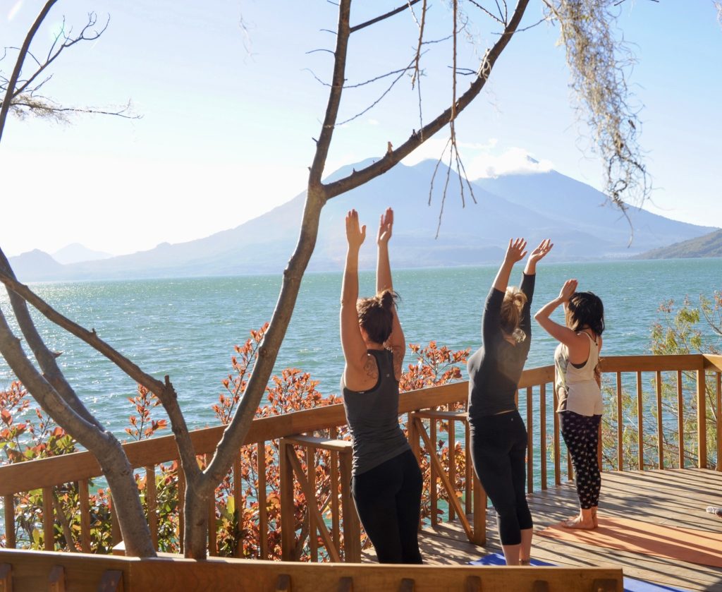Women practicing yoga overlooking Lake Atitlán in San Marcos La Laguna Guatemala