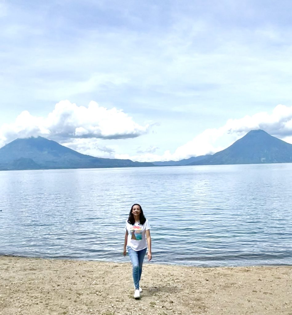 Woman walking on the beach at Hotel San Buenaventura near Panajachel with Lake Atitlán volcano views