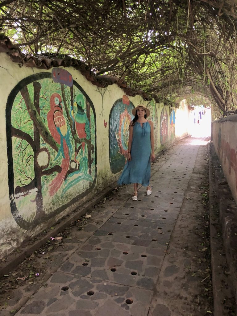 Woman walking in a mural-covered tunnel in San Marcos La Laguna Guatemala
