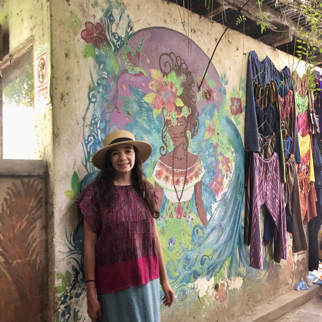 Woman standing beside a colorful mural in San Marcos La Laguna Guatemala