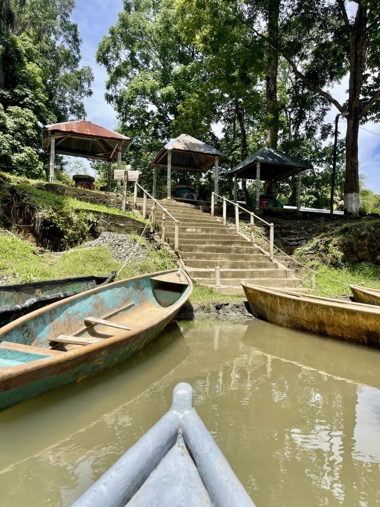Cayucos waiting at the dock at El Boquerón Guatemala with stairs, trees, and river access.