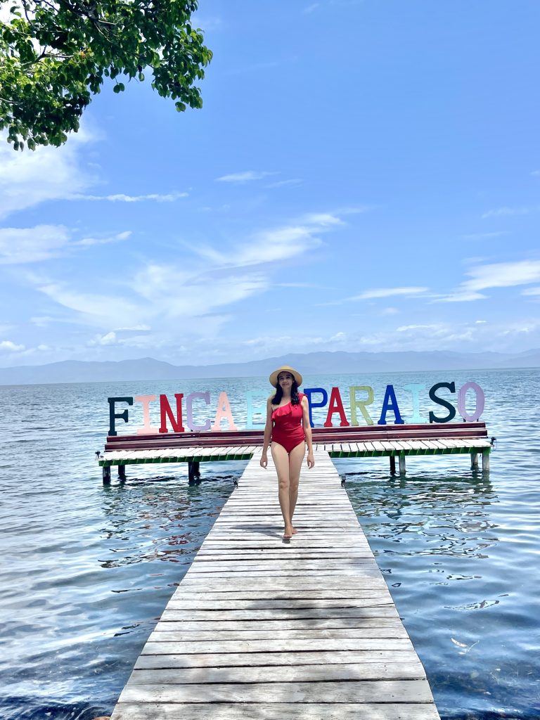 Woman walking on the Finca El Paraíso pier on Lake Izabal, Guatemala