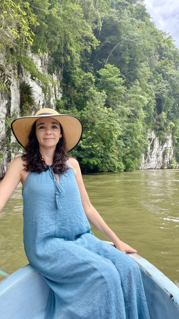 Traveler sitting in a boat on the Río Dulce canyon with jungle-covered limestone cliffs in Guatemala.canyon on the Río Dulce, Guatemala