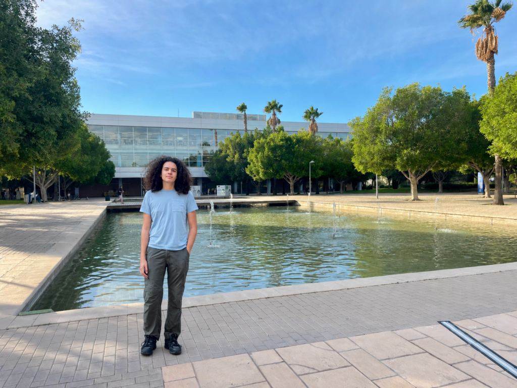 Teenage boy standing in front of a fountain at Universidad de Alicante during a university scouting trip in Spain