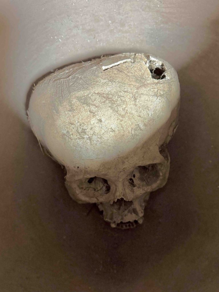 Human skull displayed inside a terracotta vessel at Chuitinamit near Santiago Atitlán.