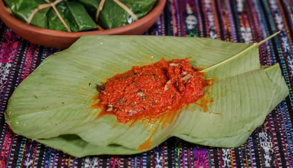 Traditional Guatemalan patín made with small fish and tomato recado served on a green maxán leaf