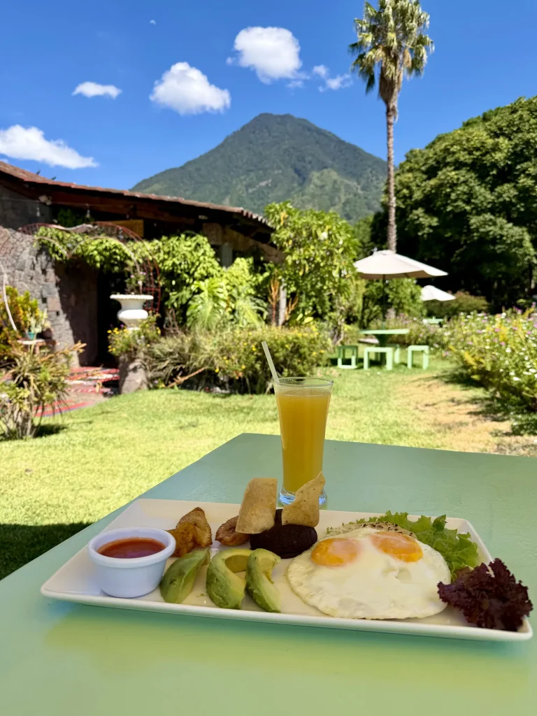 Traditional Guatemalan breakfast in the gardens at Hotel Tiosh Abaj in Santiago Atitlán with Volcán San Pedro in the background